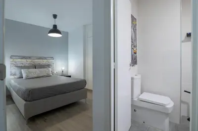 a white bedroom with a bed and a toilet at Apartment in El Mercat in Valencia