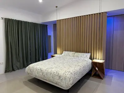 a bedroom with a large bed and a green curtain at Palm Garden Valencia in Bétera
