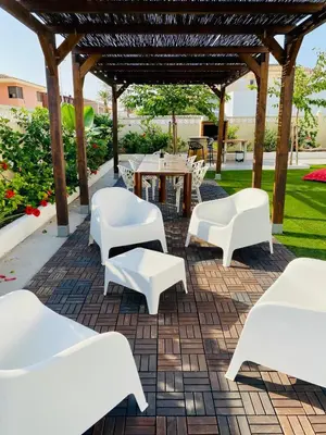 a patio with white chairs and a table at El Riuet-Chalet apartamento a 1 minuto de la playa, Cullera in Cullera