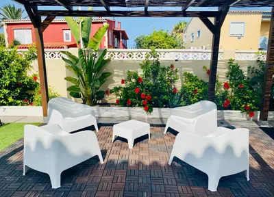a group of white chairs and tables on a patio at El Riuet-Chalet apartamento a 1 minuto de la playa, Cullera in Cullera