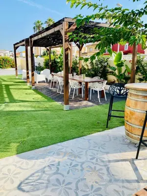 a patio with a table and chairs in the grass at El Riuet-Chalet apartamento a 1 minuto de la playa, Cullera in Cullera
