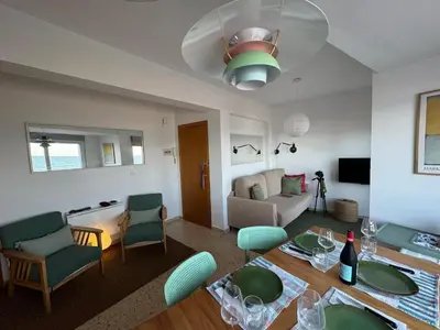 a living room with a table and chairs and a couch at Valencia Frente al mar in Valencia