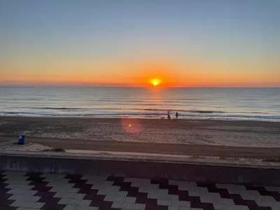 a sunset on the beach with people on the beach at Valencia Frente al mar in Valencia