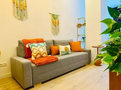 a living room with a gray couch with colorful pillows at Color & Design next to Russafa SOHO in Valencia
