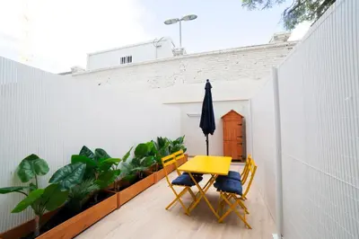 a patio with a yellow table and chairs and plants at Color & Design next to Russafa SOHO in Valencia