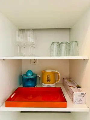 a shelf with dishes and a tea pot and a box at Color & Design next to Russafa SOHO in Valencia