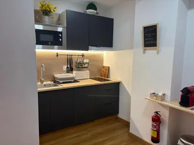 a kitchen with black cabinets and a sink at Studio 1 Port Valencia in Valencia