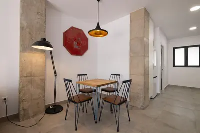 a dining room with a table and chairs and a clock at NEW BEACH Flats valencia 1 in Valencia