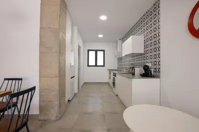 a kitchen with white counters and a table in a room at NEW BEACH Flats valencia 1 in Valencia