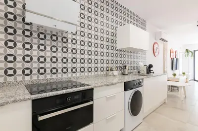 a kitchen with a black and white patterned wall at NEW BEACH Flats valencia 1 in Valencia