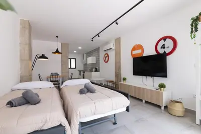 two beds in a room with a tv on the wall at NEW BEACH Flats valencia 1 in Valencia