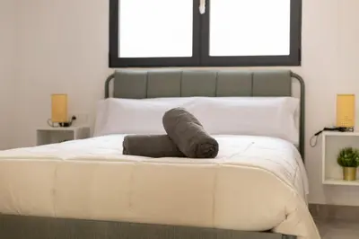 a bedroom with a white bed with two windows at NEW Beach Flats Valencia 3 in Valencia