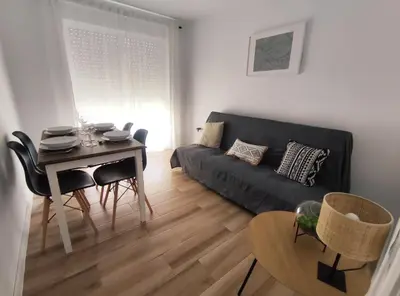 a living room with a black couch and a table at Apartamento 3 Habitaciones 2 Baños in Puerto de Sagunto