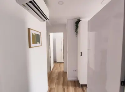 a hallway of an apartment with white walls and wooden floors at Apartamento 3 Habitaciones 2 Baños in Puerto de Sagunto