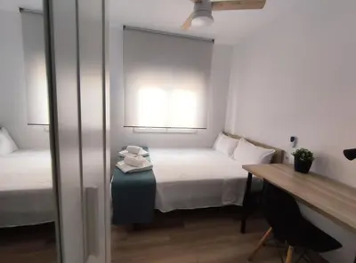 a room with a bed and a desk and a window at Apartamento 3 Habitaciones 2 Baños in Puerto de Sagunto