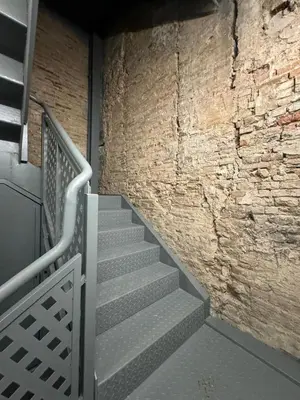 a staircase in a building with a brick wall at Tenerias Apart Corp , 4 Piso in Valencia