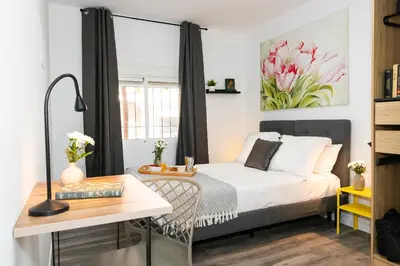 a small bedroom with a bed and a desk at SingularStays Padre Urbano in Valencia