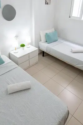 two beds in a room with two tables and two lamps at Habitación Maritim 1 in Valencia
