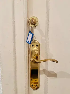 a gold door latch with a blue tag on it at Habitación Maritim 1 in Valencia