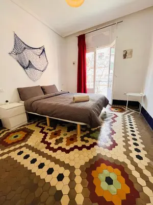 a bedroom with a bed and a rug on the floor at Habitacion Maritim 3 in Valencia