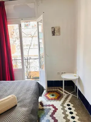a bedroom with a bed and a table and a window at Habitacion Maritim 3 in Valencia