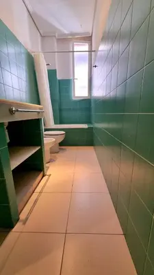 a green bathroom with two toilets and a window at Habitacion Maritim 3 in Valencia