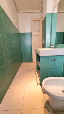 a green bathroom with a sink and a toilet at Habitacion Maritim 3 in Valencia