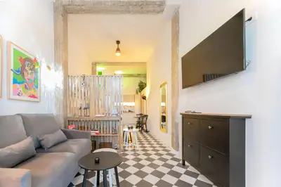 a living room with a couch and a tv on a wall at Cozy loft Jubeco in Valencia
