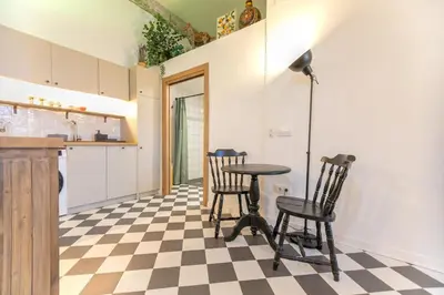a kitchen with a table and chairs on a checkered floor at Cozy loft Jubeco in Valencia