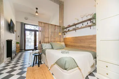 a bedroom with a bed and a checkered floor at Cozy loft Jubeco in Valencia