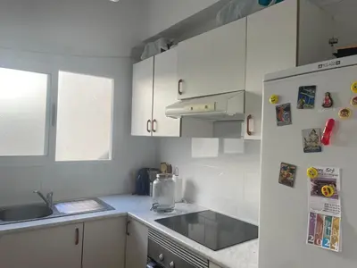 a white kitchen with a sink and a refrigerator at Cozy Appartement - Lumineux 3 pièces, à côté du Jardin de Turia in Valencia
