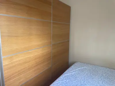 a bedroom with a wooden wall next to a bed at Cozy Appartement - Lumineux 3 pièces, à côté du Jardin de Turia in Valencia