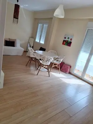 a living room with a table and chairs and a bed at Cozy Appartement - Lumineux 3 pièces, à côté du Jardin de Turia in Valencia