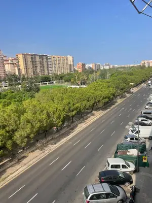 a row of cars parked on the side of a highway at Cozy Appartement - Lumineux 3 pièces, à côté du Jardin de Turia in Valencia
