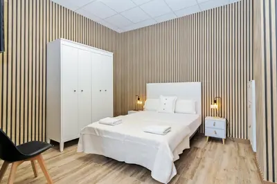 a bedroom with a large white bed and a chair at GuestReady - Quaint Stay in Valencia in Valencia