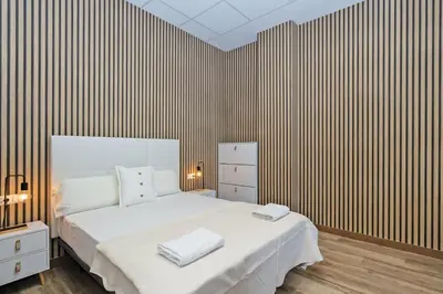 a bedroom with a large white bed and a striped wall at GuestReady - Quaint Stay in Valencia in Valencia