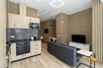 a kitchen with wooden cabinets and a tv on the wall at GuestReady - Delightful Valencian Stay in Valencia