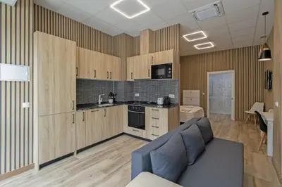 a kitchen with wooden cabinets and a blue couch in a room at GuestReady - Delightful Valencian Stay in Valencia