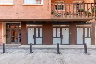 a brick building with four doors and a balcony at Travel Habitat Marítim-Serrería Lofts in Valencia