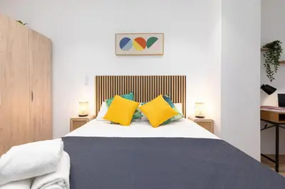a bedroom with a bed with yellow and blue pillows at Travel Habitat Marítim-Serrería Lofts in Valencia