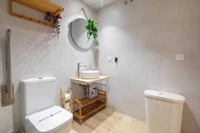 a bathroom with a white toilet and a sink at Travel Habitat Marítim-Serrería Lofts in Valencia
