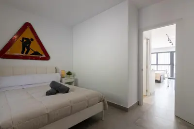 a bedroom with a bed and a sign on the wall at NEW BEACH Flats Valencia 2 in Valencia