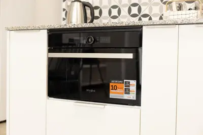 a black microwave oven in a white kitchen at NEW BEACH Flats Valencia 2 in Valencia