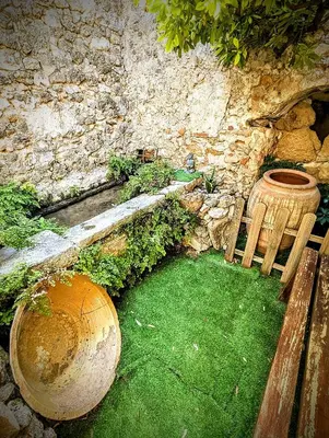 a garden with a bench and a ball and a stone wall at Casa Fina in Anna