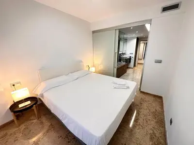 a bedroom with a large white bed and a chair at Amplio y Lujoso con vistas in Valencia