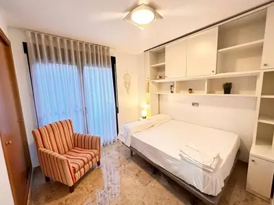 a bedroom with a bed and a chair at Amplio y Lujoso con vistas in Valencia