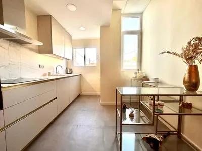 a kitchen with white cabinets and a potted plant at Stylish Ruzafa Market in Valencia