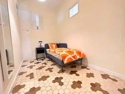 a bedroom with a bed with an orange comforter at Stylish Ruzafa Market in Valencia