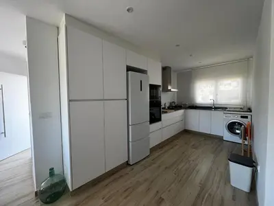 a kitchen with white cabinets and a white refrigerator at Acogedora casa con piscina in Lliria