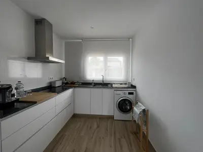 a kitchen with a washing machine and a window at Acogedora casa con piscina in Lliria